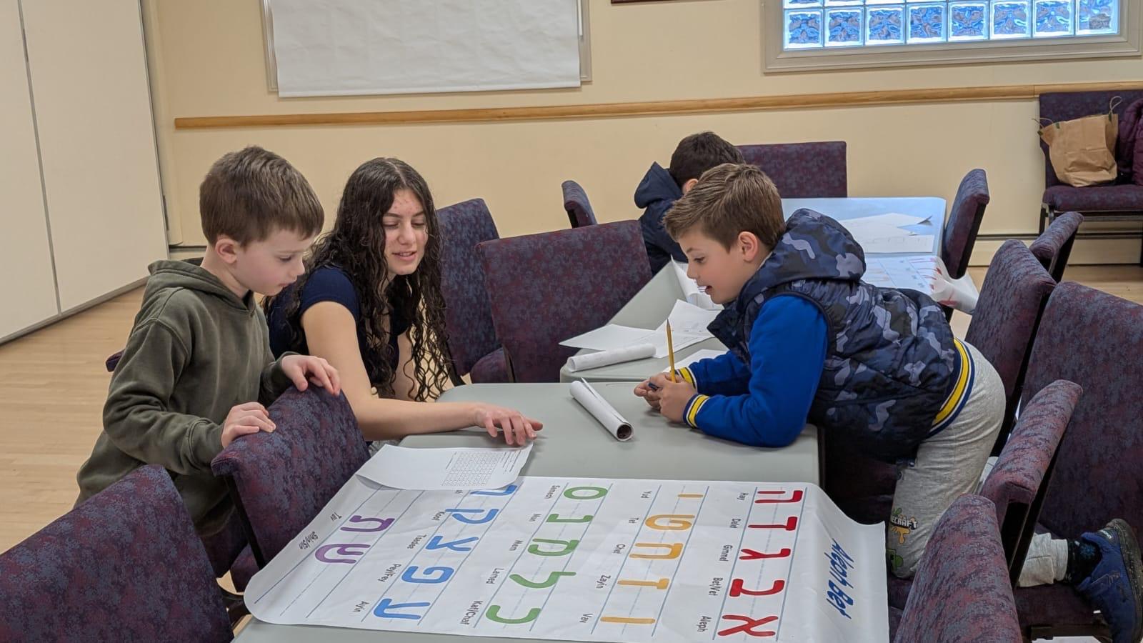 Older Hebrew School students learning together with a teacher